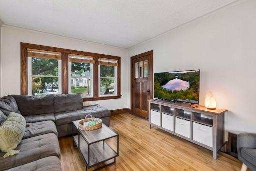 Bright living room with original hardwood floors and woodwork.