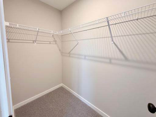 PHOTO OF A DIFFERENT HOME WITH SIMILAR PLAN AND FINISHES. Primary Suite Walk-in Closet.