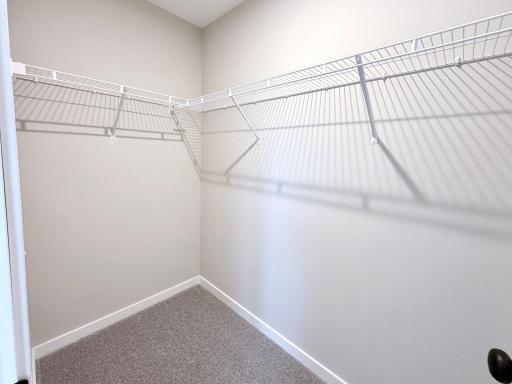 PHOTO OF A DIFFERENT HOME WITH SIMILAR PLAN AND FINISHES. Primary Walk-in Closet.