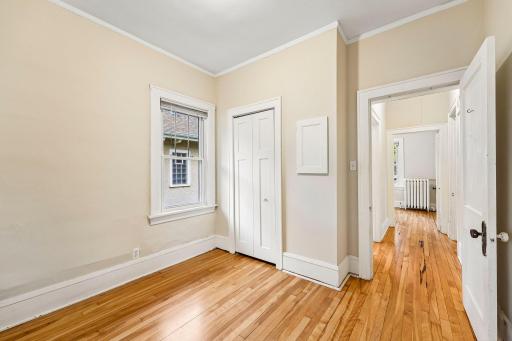 Bedroom with closet storage and classic window trim