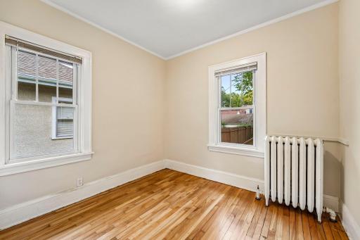 Main-level bedroom with hardwood floors and natural light