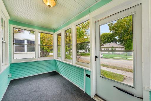Bright enclosed front porch surrounded by windows
