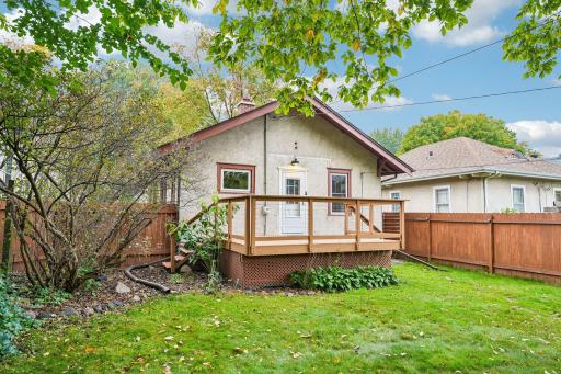 Rear exterior view of the home, deck, and yard