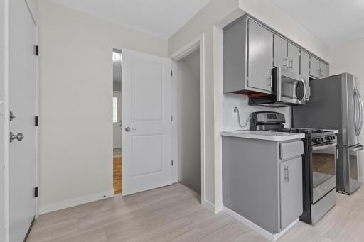 Convenient access just off the kitchen leads directly to the attached garage, with the open doorway providing access to the finished lower level.