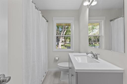 The full bathroom has been refreshed with a new vanity, toilet, mirror, lighting and updated tub and shower fixtures.