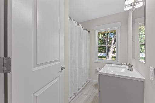Clean and bright, the remodeled full bathroom offers several new fixtures and finishes for a fresh, updated feel.