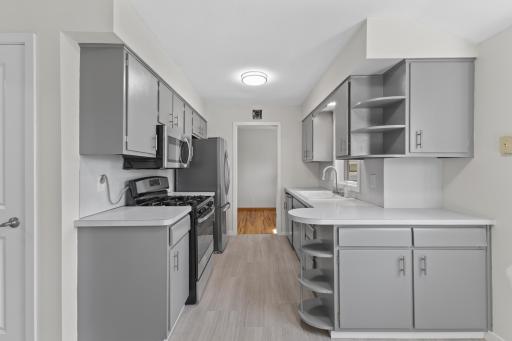 The kitchen received a thoughtful refresh with painted cabinetry, new hardware, updated lighting, fresh paint and new luxury vinyl tile flooring.
