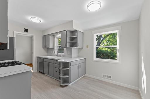 Updated kitchen and informal dining area featuring new luxury vinyl tile flooring, fresh paint, new appliances, hardware and new lighting. Natural light floods this space through the new windows!
