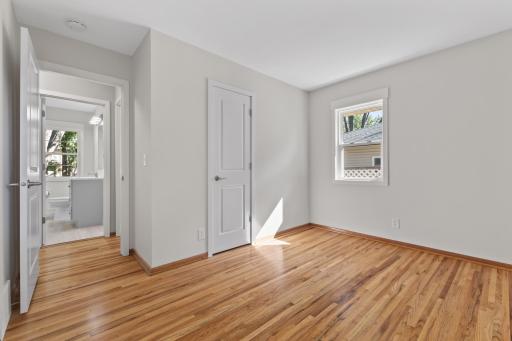 Another comfortable main-level bedroom with warm hardwood floors and a clean, neutral finish. Convenient to the bathroom and two other main level bedrooms.