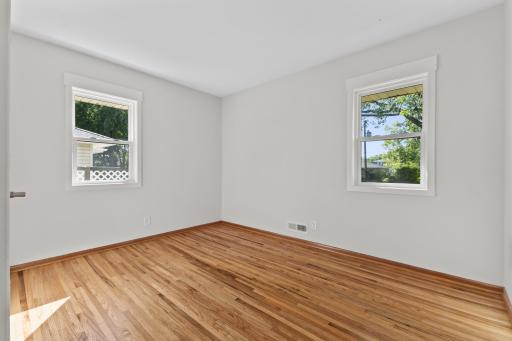 Main-level bedroom featuring refinished hardwood floors, fresh paint, and new windows. You'll enjoy having three bedrooms on the main level.