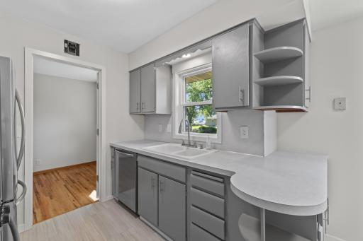 A closer look at the refreshed cabinetry, new hardware, new faucet and bright workspace surrounding the kitchen sink.