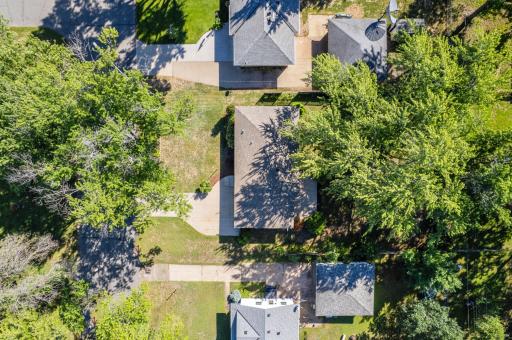 Overhead view of the property provides a closer look at the home's footprint, driveway and surrounding yard.