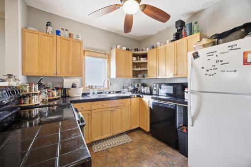 Updated kitchen with ceiling fan and tiled counter tops. Dishwasher too! Eat in kitchen with laundry to the left.