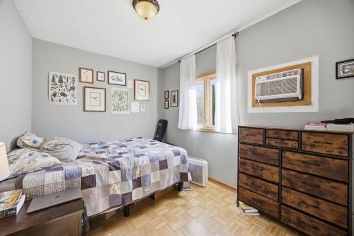 Middle upper bedroom with updated window and wall air conditioner.