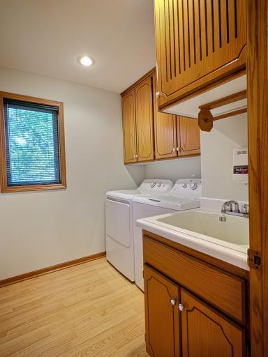 Main level laundry room with full upper cabinets and laundry sink. Bonus laundry chute from the upper level.