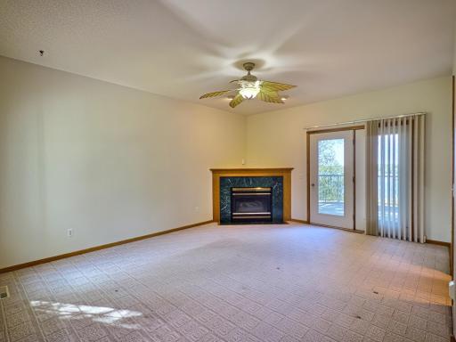 Main floor living room with corner gas fireplace and access out to the expansive lakeside deck.
