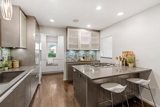 Kitchen with Custom Cabinets, Quartz Countertops, High-End Appliances, and Tiled Backsplash