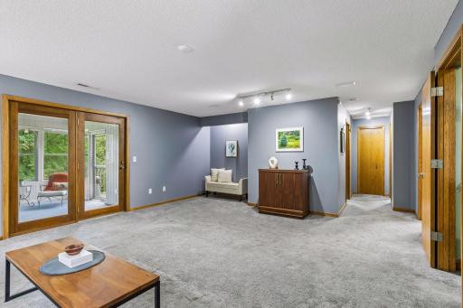 Spacious lower level family room stepping out into the 3-season porch