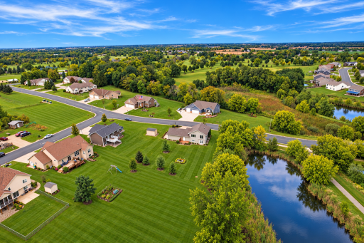 AI Drone shot of back of house with park area and pond.png