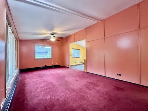 The front entry and living room is bright and colorful. Paint and flooring will transform this place.