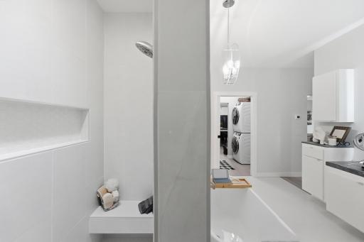 Large niche shelving for toiletries. Comfortable bench to relax while you shave. Open shower, no door and no curb. Laundry room easily accessible from your private suite.