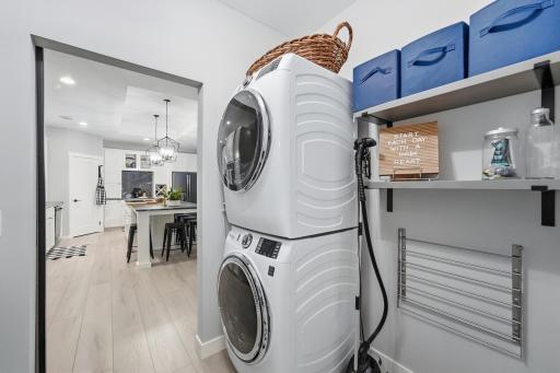 Designated laundry with barndoor, walks through from kitchen to primary bathroom. Stackable washer/dryer, built-in shelving, drying rack and folding table. Walls with noise-reduction insulation!