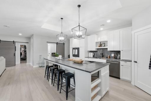 10'x4' island with seating for six counter-height stools, 5-burner stovetop, hidden microwave in island and a second hookup for future microwave over the wall oven. Multiple cabinets & drawers with custom pullouts, dividers and organizers.