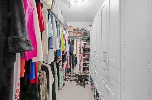 Custom organization with variety of hang, shelves, drawers, cabinets, shoe racks and more. Bright lighting and pocket door at entry.