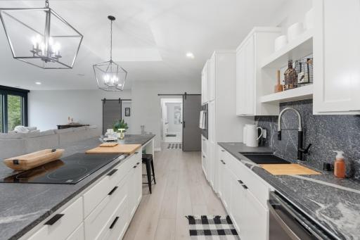 Kitchen — Bright, modern kitchen featuring abundant cabinetry, expansive granite countertops, oversized center island, black slate stainless appliances and generous workspace for cooking & entertaining.