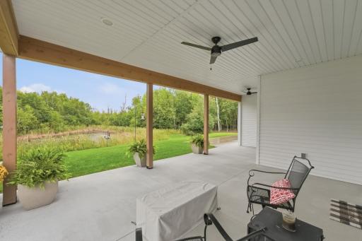 Covered back porch, finished ceiling with fans, warmth of wood with chunky beams and posts framing the view. Electrical in place for future retractable screens - opportunity to convert to future 4-season porch.
