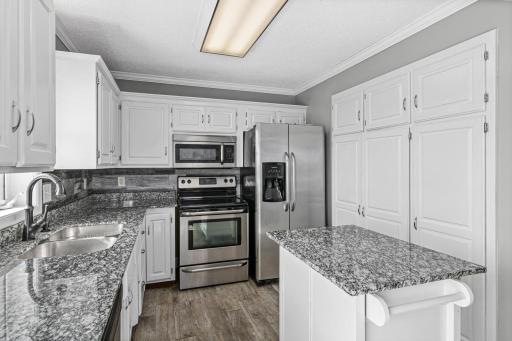 Modernized kitchen with stainless steel appliances, center island, and pantry