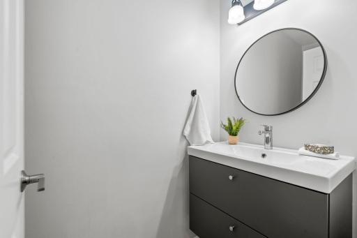 A convenient ½ bath features a floating vanity, updated in 2023.
