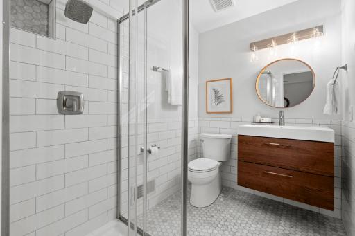 The private ensuite features a tiled walk-in shower, tile flooring, and floating vanity, fully updated in 2023!