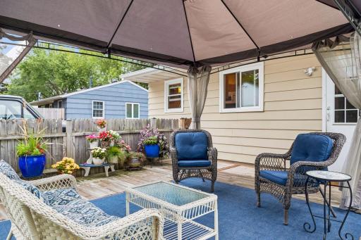 Fenced-in backyard featuring a Wood patio with a metal canopy for shade and a raised bed garden.