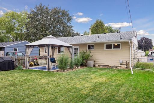 Fenced-in backyard featuring a Wood patio with a metal canopy for shade and a raised bed garden.