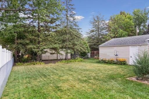 Fenced-in backyard featuring a Wood patio with a metal canopy for shade and a raised bed garden.