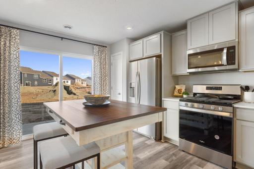 Dining area and kitchen with easy access to private rear patio. Photo is of model home. Colors and options may vary. Ask Sales Agent for details.