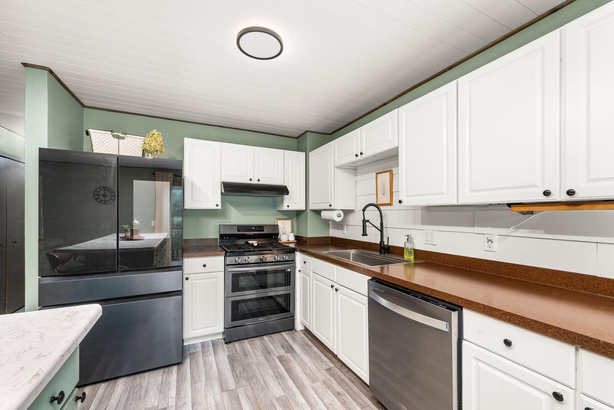 The beautiful updated kitchen features a large center island, breakfast bar, new appliances and gas range.