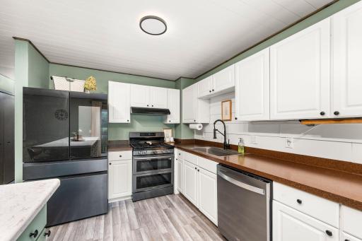 The beautiful updated kitchen features a large center island, breakfast bar, new appliances and gas range.