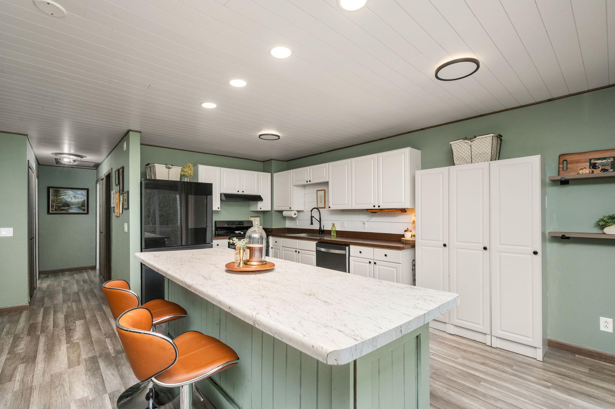 The beautiful updated kitchen features a large center island, breakfast bar, new appliances and gas range.
