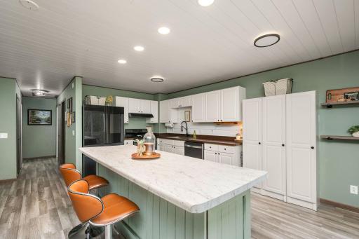 The beautiful updated kitchen features a large center island, breakfast bar, new appliances and gas range.
