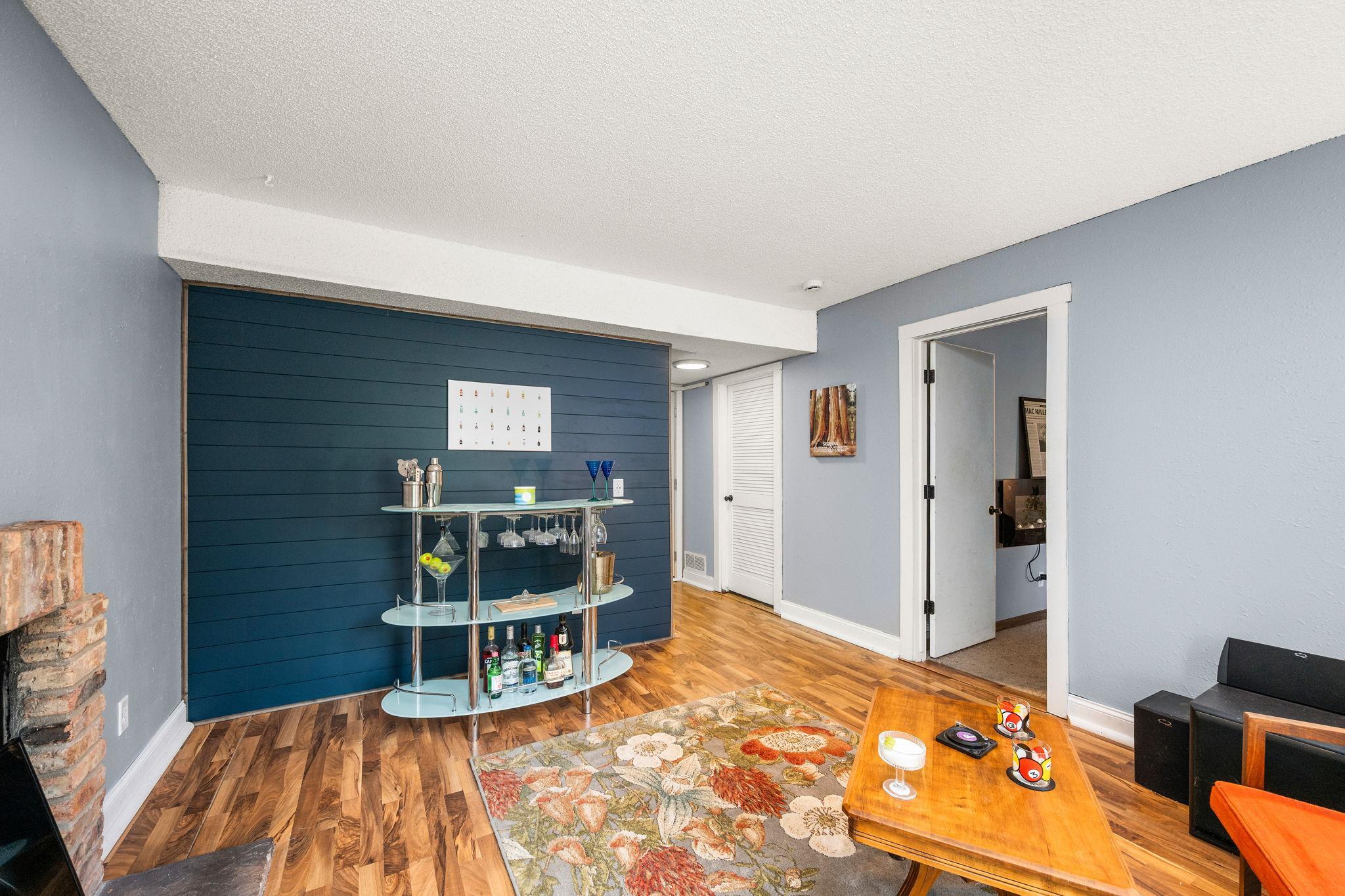 The walkout lower level features a family room, 3rd bedroom, wood-burning fireplace, storage area, laundry room with a utility sink, and a bathroom accented with ship-lap and a newer vanity.