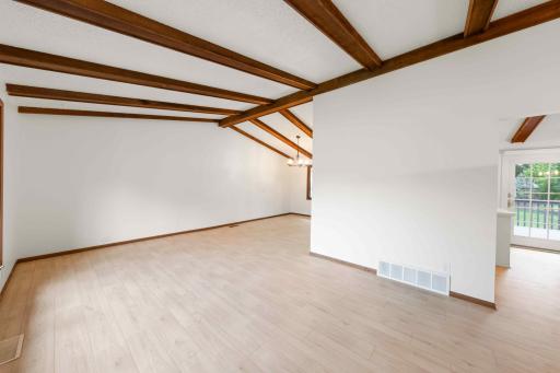 Bright, open living areas with updated flooring and beautiful exposed beams throughout