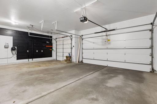 Finished garage with slat wall panel organization system and EV charger.