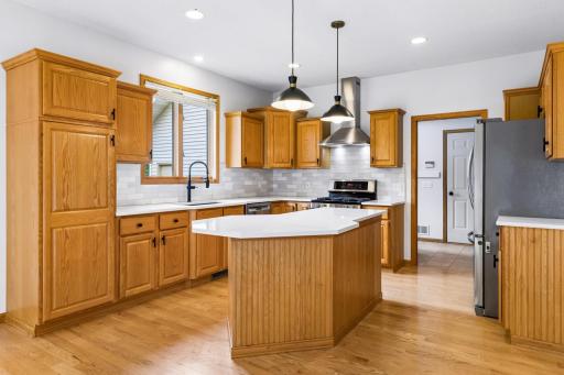 Remodeled kitchen will all new quartz counters and offset subway tile backsplash, sink, faucet, range hood and lighting.