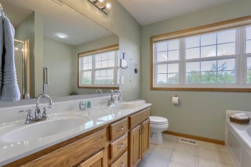 Private full bath featuring a dual-sink vanity, walk-in shower and soaking tub!