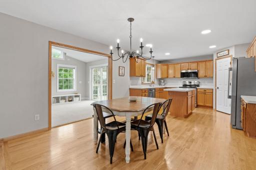 dining room with sunroom in back left and kitchen on back right