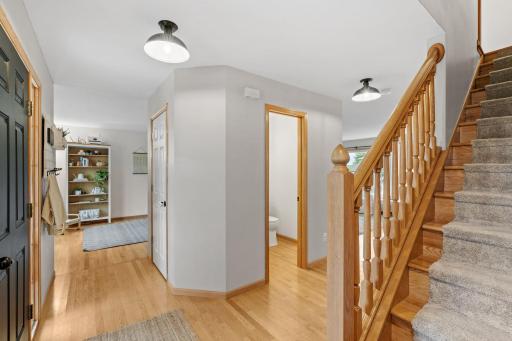 front office on left, bathroom doorway, stairs leading upstairs