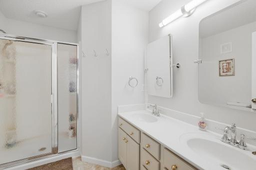 Primary 3/4 bath with double sinks, Rejuvenation mirror and hardware/fixtures, Delta faucets, updated in 2023.