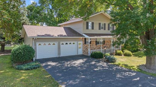 The curb appeal is hard to beat with well kept and cared for hedges and shrubs, brick accents, a charming covered front porch, asphalt driveway, and a font lamp making a statement.